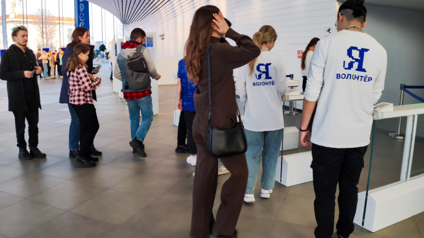 Очередь посетителей и волонтёров у входной зоны павильона «Атом»