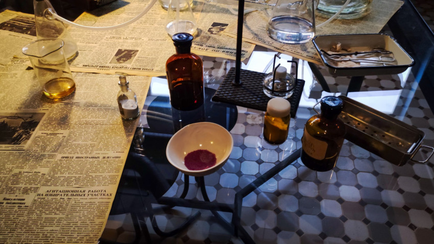 Химические реагенты и лабораторные приборы на стеклянном столе экспозиции павильона «АТОМ»