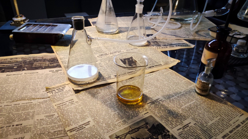 Лабораторные колбы и стеклянная система на столе экспозиции павильона «АТОМ»