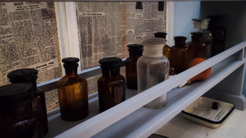 Лабораторные бутылки на нижней полке стеллажа павильона «АТОМ»