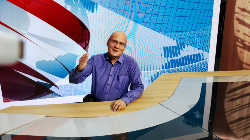 Посетитель за новостным столом демонстрационной студии в павильоне №75