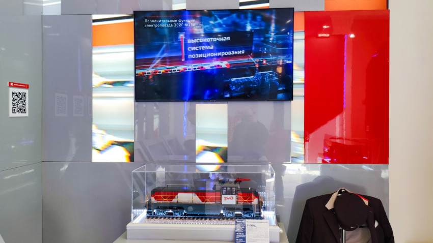 Макет маневрового электровоза РЖД и экран с презентацией систем позиционирования