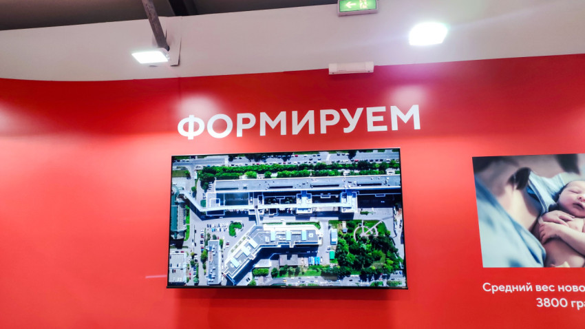 Экран с аэрофотосъёмкой медицинского комплекса на стенде выставки