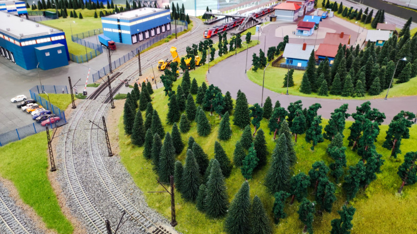 Макет железнодорожной линии с рабочей техникой и лесным массивом