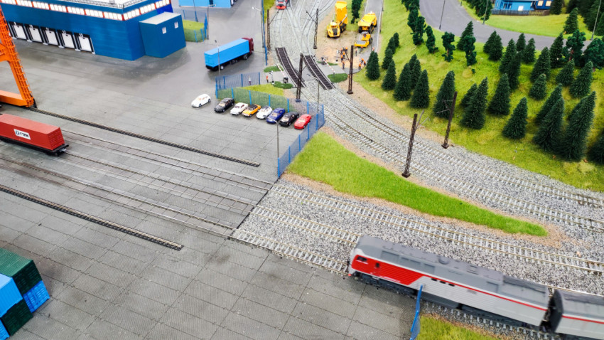 Макет железнодорожных путей с грузовым терминалом и движущимся поездом