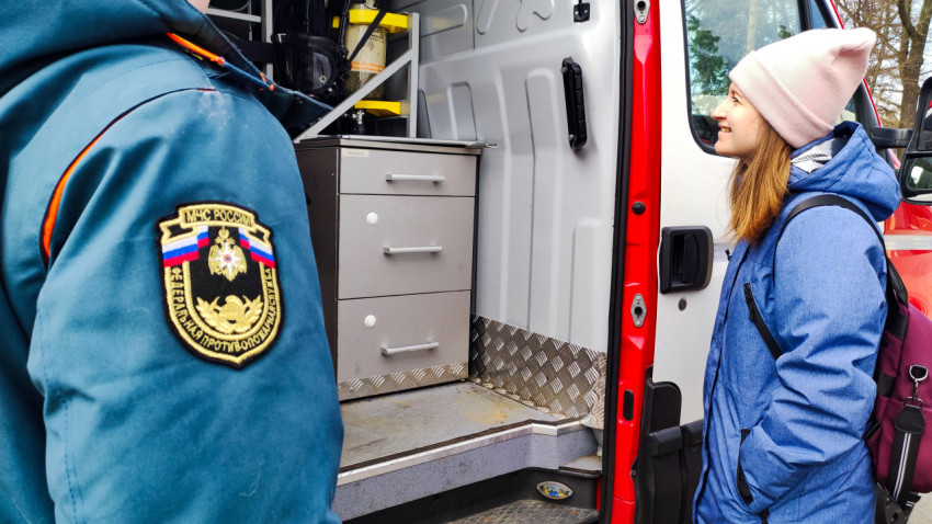 Сотрудник МЧС показывает оборудование спецавтомобиля посетительнице выставки