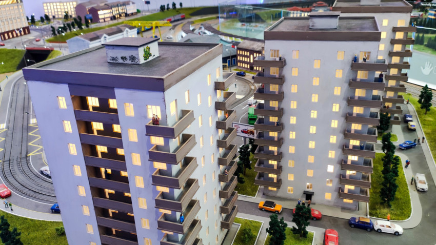 Макет многоэтажных жилых домов с уличным движением и рельсовой инфраструктурой