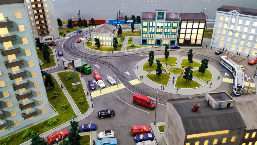 Макет городского круга движения с трамваем, зданиями и зелёным сквером