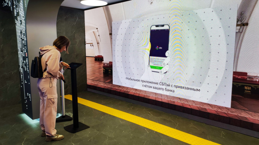Экран с иллюстрацией мобильного приложения СБПэй и посетитель у терминала