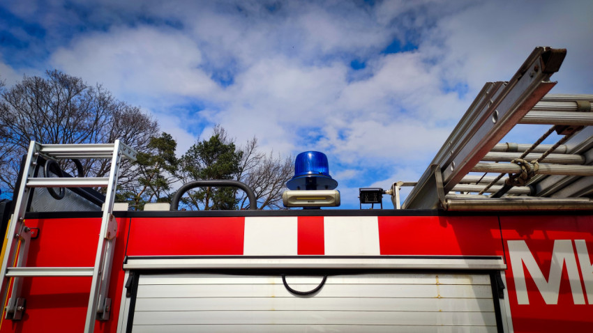 Синяя проблесковая лампа и лестничное оборудование на крыше пожарного автомобиля