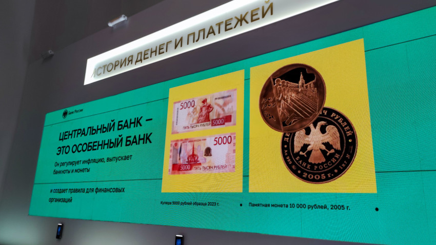 Экран с банкнотами и монетами в экспозиции о роли Центрального банка