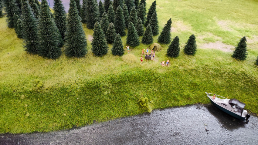 Макет берега реки с туристическим лагерем и моторной лодкой