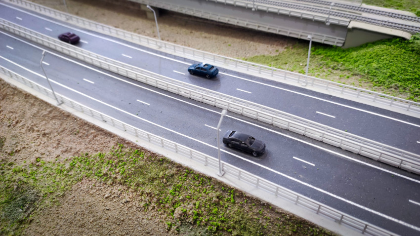 Фрагмент масштабной модели автомагистрали с миниатюрными автомобилями