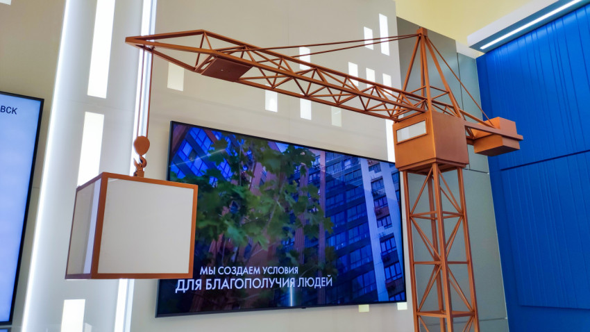 Экспозиционный макет крана перед медиаэкраном в павильоне «Поволжье»