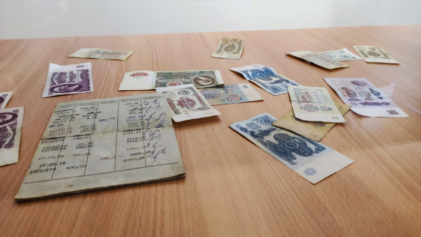 Советские банкноты и раскрытая сберегательная книжка на столе