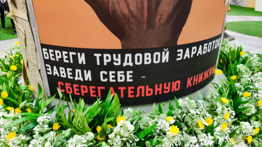 Нижняя часть советского плаката о сберегательной книжке в оформленной выставочной зоне