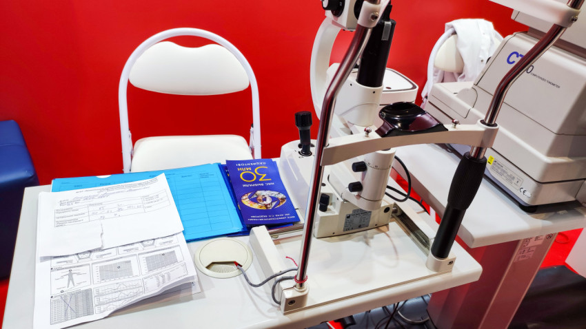 Щелевая лампа и рабочие материалы офтальмолога на выставочном стенде