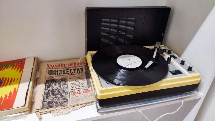 Винтажный проигрыватель с пластинкой и советскими печатными материалами