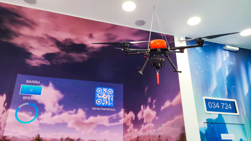 Беспилотник в демонстрационной зоне с медиапанелью и игровым интерфейсом