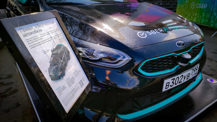 Информационная стойка и передняя часть беспилотного автомобиля SberAutotech на выставке