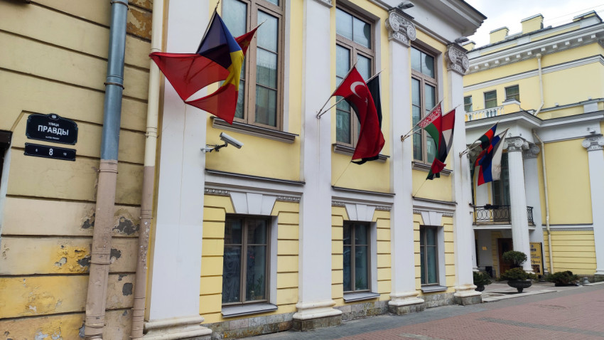 Фасад исторического здания гостиницы Эрмитаж с государственными флагами