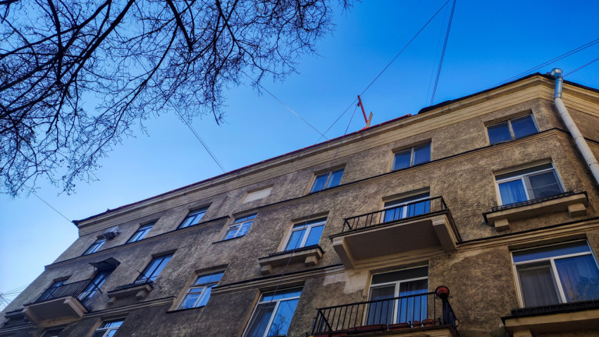 Фасад жилого дома с балконами и верхними этажами