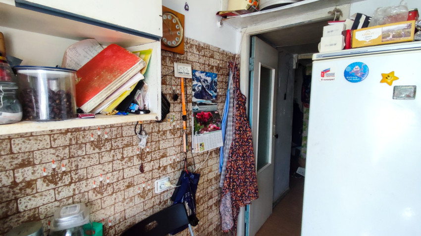 Кухонная зона с холодильником, полками и настенным календарем