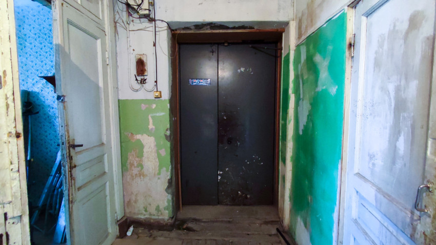 Коридор с закрытой металлической дверью в старом здании