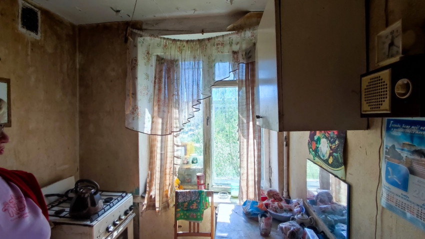 Кухня с окном, плитой и навесными шкафами