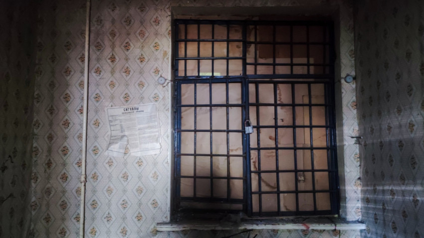 Решетчатое окно и обои с узором в старом помещении