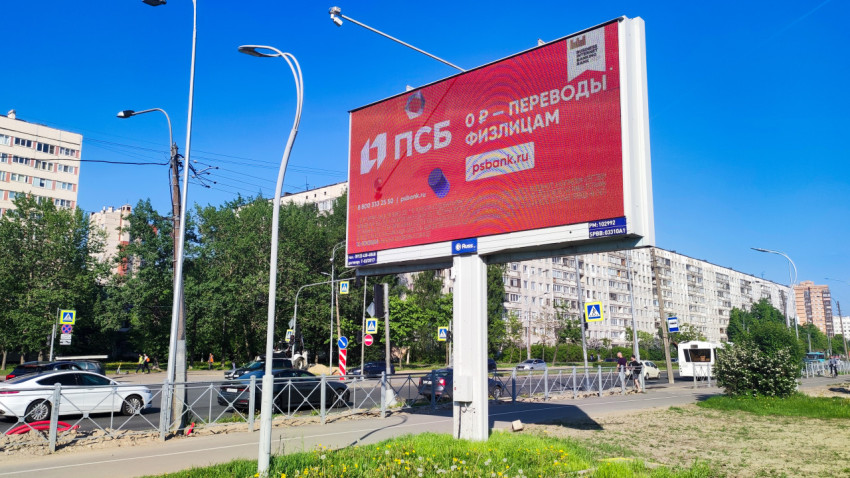 Цифровой билборд с рекламой переводов на фоне жилого района