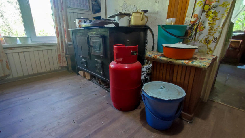 Металлическая плита и газовый баллон в сельской кухне