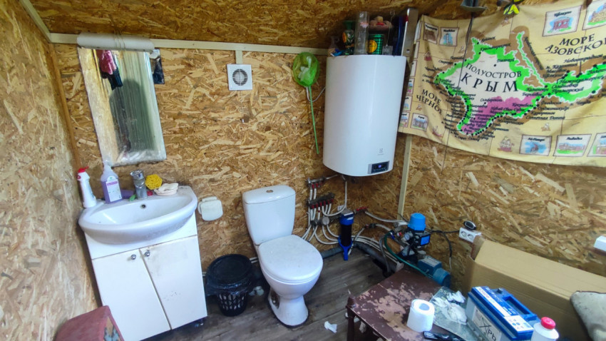Санузел с умывальником, бойлером и картой Крыма на стене