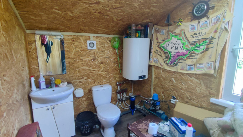 Помещение санузла с бойлером, туалетом и декоративным полотнищем