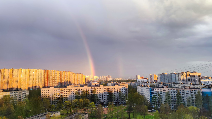 Городской пейзаж с радугой над жилыми домами