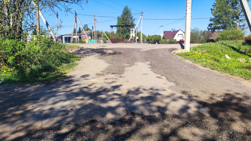 Перекрёсток грунтовых улиц с опорами ЛЭП и частными постройками