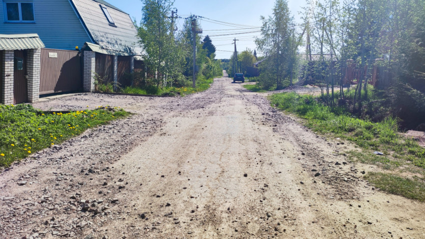 Грунтовая дорога частного сектора с жилым домом и опорами ЛЭП