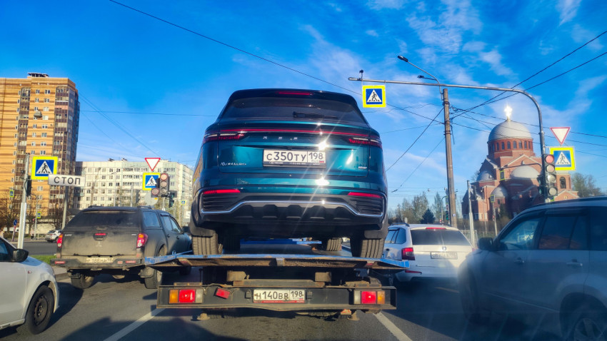 Автомобиль на эвакуаторе на городском перекрёстке