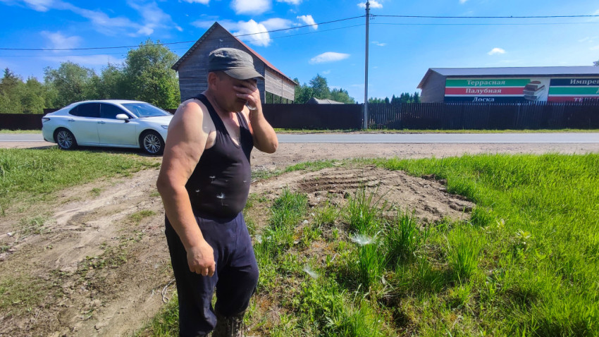 Мужчина на придорожном участке рядом с легковым автомобилем