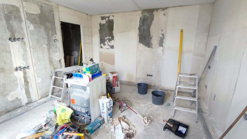 Комната в процессе ремонта со стремянками и строительными материалами