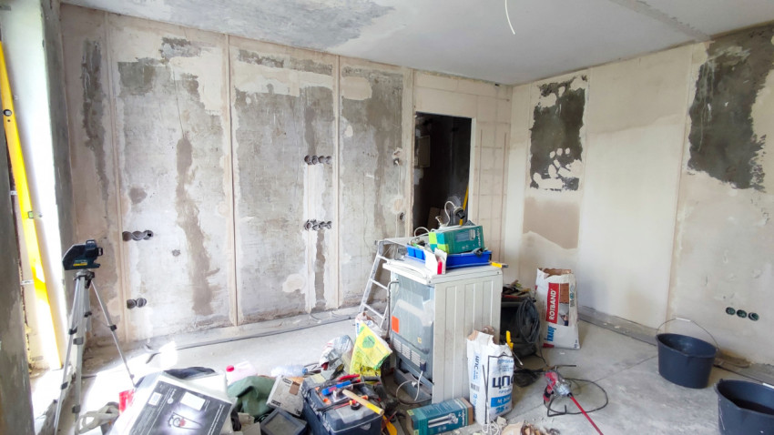 Процесс ремонта в комнате с инструментами и частично подготовленными стенами