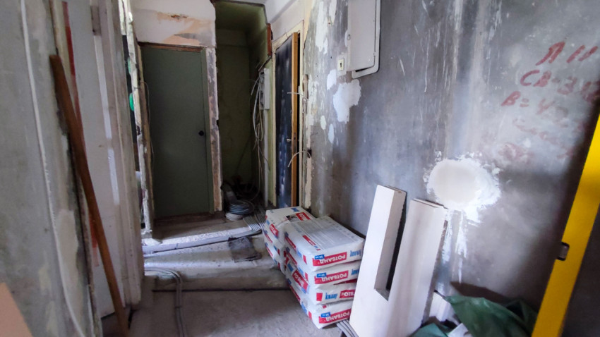 Коридор в квартире на этапе чернового ремонта с материалами и проводкой