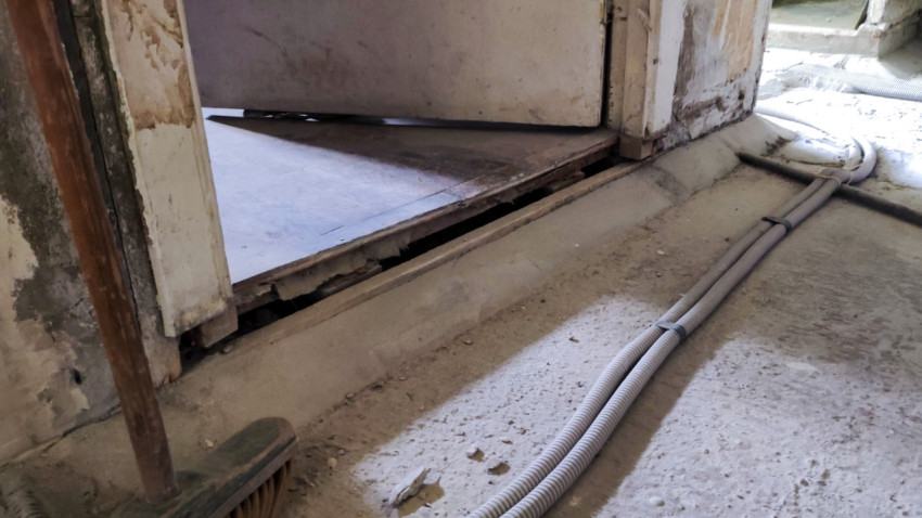 Проложенная проводка в полу у старого дверного проёма в помещении ремонта