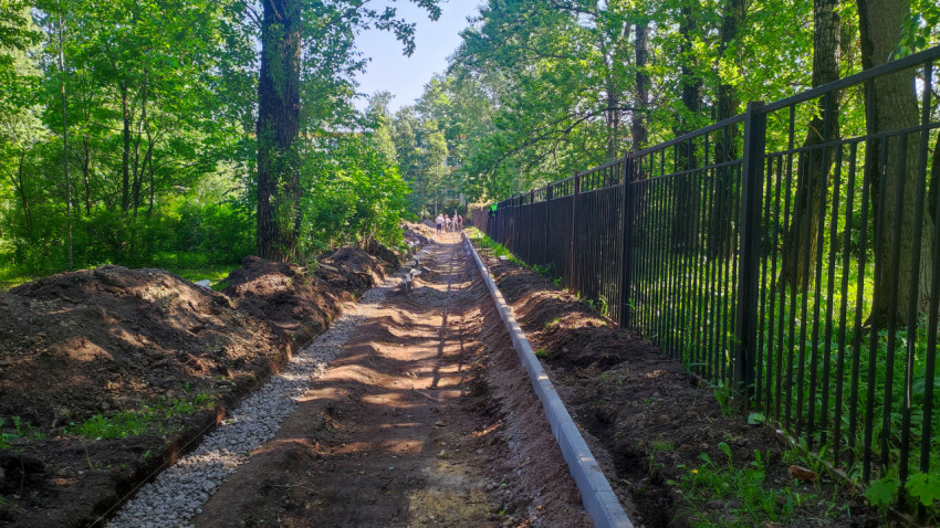 Траншея с бордюрами и рабочими на дальнем плане
