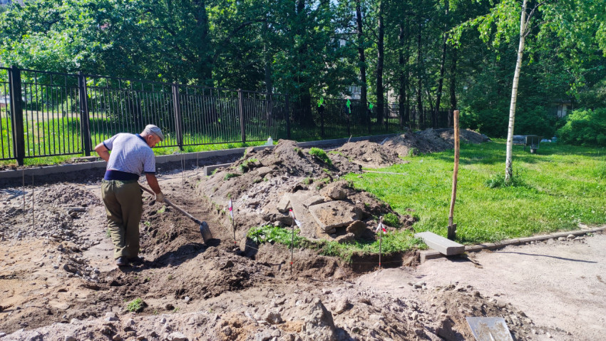 Рабочий разравнивает грунт на участке ремонтных работ