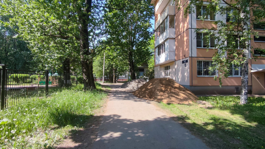 Дворовая территория с домом и строительными материалами на тропе