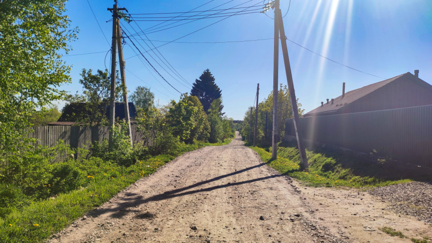 Грунтовая дорога между частными участками с линиями электропередачи