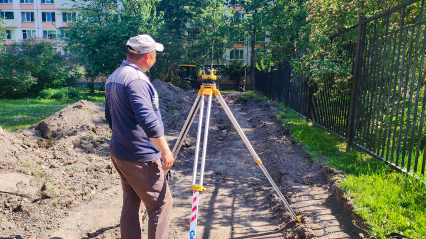 Геодезист выполняет измерения на строительной площадке