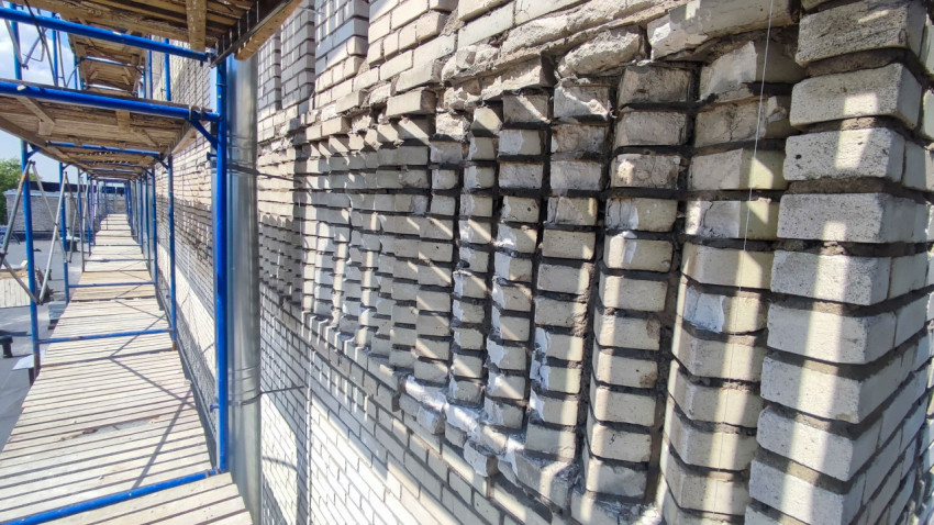 Ремонт фасада кирпичного здания на строительных лесах