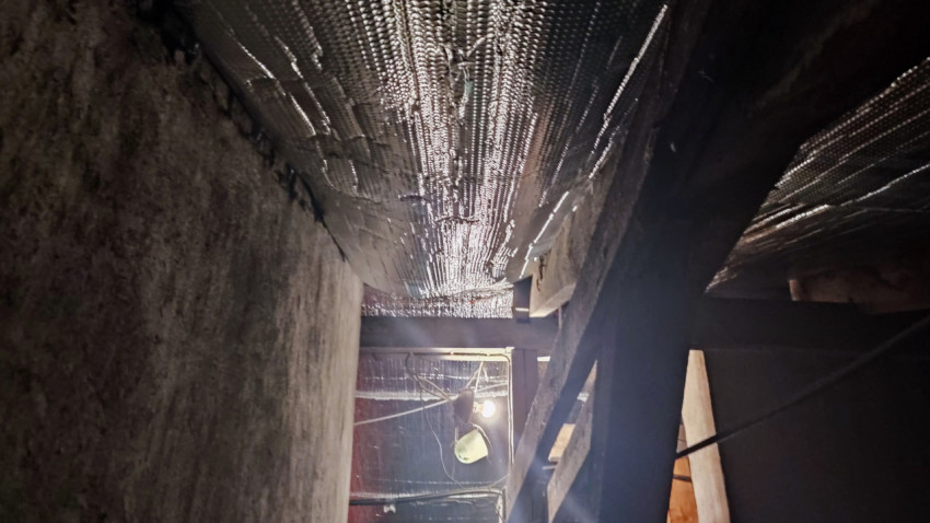 Пролёт с утеплителем, деревянными балками и временным освещением